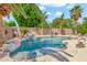 Refreshing backyard pool with rock features, lush greenery, and ample space for outdoor entertainment at 3044 E Sparrow Pl, Chandler, AZ 85286