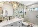 Stylish bathroom featuring a vanity with a marble countertop, modern fixtures, and a shower with white vertical tiles at 3115 N 34Th Pl, Phoenix, AZ 85018
