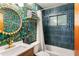 Bathroom features a shower-tub, unique wallpaper, updated fixtures, and a large decorative mirror at 3115 N 34Th Pl, Phoenix, AZ 85018