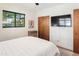 Spacious bedroom features a ceiling fan, hardwood floors, natural lighting, and a mounted flat screen TV at 3115 N 34Th Pl, Phoenix, AZ 85018