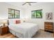 Bright bedroom featuring hardwood floors, a ceiling fan, two windows, and classic furnishings at 3115 N 34Th Pl, Phoenix, AZ 85018