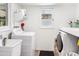 Bright laundry room with modern washer and dryer, utility sink, storage shelves, and natural light at 3115 N 34Th Pl, Phoenix, AZ 85018