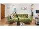 Stylish living room featuring a green sofa, art and wood-look floors at 3115 N 34Th Pl, Phoenix, AZ 85018