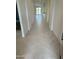 Bright hallway featuring herringbone tile floors and white walls, leading to an outdoor view at 31274 N 130Th Ave, Peoria, AZ 85383