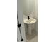 Stylish powder room with a sleek pedestal sink, modern faucet, and decorative round mirror at 31274 N 130Th Ave, Peoria, AZ 85383