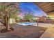 Cozy backyard featuring a pool, mature trees, desert landscaping and a covered patio at 317 E Belmont Ave, Phoenix, AZ 85020