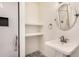Bathroom featuring a white pedestal sink, tiled shower, and built-in shelves at 317 E Belmont Ave, Phoenix, AZ 85020
