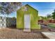 A green storage shed sits on gravel under a tree with concrete blocks as a fence at 317 E Belmont Ave, Phoenix, AZ 85020