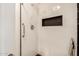 Walk-in shower with white tile, black trim, and built-in niche at 317 E Belmont Ave, Phoenix, AZ 85020