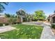 Expansive backyard with a lush lawn, stone pavers, desert landscaping, and a sparkling pool at 3648 E Fargo St, Mesa, AZ 85205