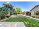 Expansive backyard with mature trees, a lush lawn, stone pavers, and a sparkling pool at 3648 E Fargo St, Mesa, AZ 85205
