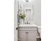 A powder room with a white vanity, quartz countertop, and a modern, decorative mirror at 3648 E Fargo St, Mesa, AZ 85205
