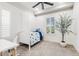 Clean bedroom features a white bed, a desk and a window with a shutter, with a nice potted plant at 3648 E Fargo St, Mesa, AZ 85205