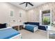 Cozy bedroom boasts two twin beds, a desk with floral wallpaper on one wall and shutters on the windows at 3648 E Fargo St, Mesa, AZ 85205