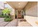 Inviting front porch with stone tile, desert landscaping, and a solid wood front door at 3648 E Fargo St, Mesa, AZ 85205