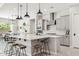 Bright open kitchen with a large island with bar stool seating, stainless steel appliances, and modern pendant lighting at 3648 E Fargo St, Mesa, AZ 85205