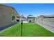 The backyard has a synthetic grass lawn, gravel border, block wall, and gazebo, ideal for outdoor living at 38086 W Isabella Ln, Maricopa, AZ 85138