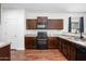 Stylish kitchen featuring dark wood cabinets, practical layout, and easy access to appliances at 38086 W Isabella Ln, Maricopa, AZ 85138