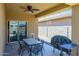 Covered patio featuring a ceiling fan, dining table, grill and sliding glass door at 38086 W Isabella Ln, Maricopa, AZ 85138