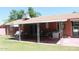 Covered patio with brick exterior, lawn, table and chairs, and motorcycle at 3942 N 38Th St, Phoenix, AZ 85018