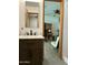 Bathroom vanity with marble countertop and view into adjacent bedroom with ceiling fan and desk area at 3942 N 38Th St, Phoenix, AZ 85018