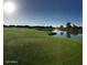 Scenic golf course featuring a pristine green, tranquil water hazards, and clear blue skies for an enjoyable day of golf at 4050 N Terra Mesa Cir, Mesa, AZ 85207