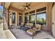 Relaxing covered patio features comfortable seating, a ceiling fan, and views of the outdoor area at 4050 N Terra Mesa Cir, Mesa, AZ 85207