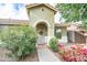 Charming covered entry with an arched doorway, wreath, and lush landscaping at 4110 E Brighton Way, San Tan Valley, AZ 85140