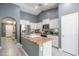 Bright kitchen boasts white cabinets, stainless appliances, granite countertops and a breakfast bar island at 4110 E Brighton Way, San Tan Valley, AZ 85140