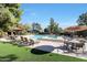 Community pool area with multiple lounge chairs and tables under a sunny blue sky at 4116 E Lupine Ave, Phoenix, AZ 85028