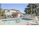 Community pool with sun loungers and umbrellas, surrounded by a white fence and lush trees at 4116 E Lupine Ave, Phoenix, AZ 85028