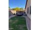 View of a compact backyard with a small lawn and a utility trailer parked in a side area at 4130 E Megan St, Gilbert, AZ 85295