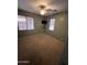 Empty bedroom with two windows, shelves with TV, neutral carpet and light green walls at 4130 E Megan St, Gilbert, AZ 85295