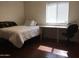 A bedroom features a well-lit space with hardwood flooring, a bed, and a desk at 42 W Thomas Ln, Tempe, AZ 85281