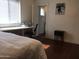 Bright bedroom with a window, hardwood floors, and a desk, offering a comfortable living space at 42 W Thomas Ln, Tempe, AZ 85281