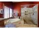 Relaxing bathroom with a soaking tub, tiled shower, and warm lighting at 4441 E Sunnyside Ln, Phoenix, AZ 85032
