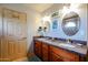 Bathroom featuring granite counters, double sinks, tiled floors, and oval mirrors and updated lighting fixtures at 4441 E Sunnyside Ln, Phoenix, AZ 85032