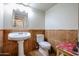 Powder room with pedestal sink, toilet, and tile wainscoting at 4441 E Sunnyside Ln, Phoenix, AZ 85032