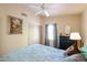 A well-lit bedroom features a ceiling fan, neutral walls, and a cozy bed with soft blue bedding at 4441 E Sunnyside Ln, Phoenix, AZ 85032