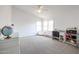 Spacious bedroom with neutral carpet, white walls, a ceiling fan, and plenty of natural light from the windows at 4441 E Sunnyside Ln, Phoenix, AZ 85032