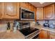 Close-up of stainless steel oven, cooktop, and microwave appliances in the kitchen area at 4441 E Sunnyside Ln, Phoenix, AZ 85032