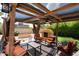 Outdoor covered seating area with grill, chimney and lights strung overhead in backyard at 4441 E Sunnyside Ln, Phoenix, AZ 85032