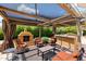Outdoor seating under a wooden pergola, complete with lights, a chimney, and patio furniture at 4441 E Sunnyside Ln, Phoenix, AZ 85032