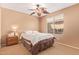 Comfortable bedroom features neutral walls, plush carpet, and a ceiling fan with leaf-shaped blades at 44454 W Oster Dr, Maricopa, AZ 85138