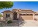 Welcoming single-story home with a two-car garage and tidy desert landscaping under a clear blue sky at 44454 W Oster Dr, Maricopa, AZ 85138