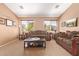 Formal living room with plush sofas, carpeted floors, and sunny windows offering neighborhood views at 44454 W Oster Dr, Maricopa, AZ 85138