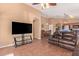 Open living room and dining area with tile flooring, leather seating, and modern entertainment center at 44454 W Oster Dr, Maricopa, AZ 85138