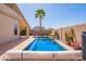 A view of the private pool with its cover, surrounded by desert landscaping and a tall palm tree at 44454 W Oster Dr, Maricopa, AZ 85138