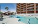 Community swimming pool with lounge chairs, a gazebo, and a multi-story condo in the background at 4750 N Central Ave # D15, Phoenix, AZ 85012