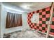Dilapidated bedroom featuring a checkered accent wall and natural light at 4870 W Almeria Rd, Phoenix, AZ 85035